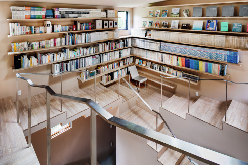 Die Wand entlang der Wendeltreppe ist als auskragendes Bücherregal gestaltet.<br />