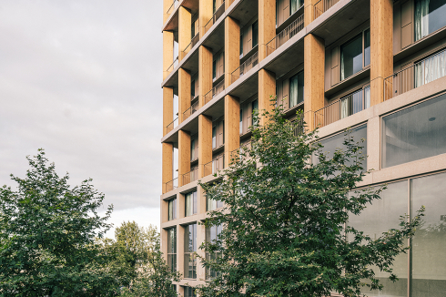 Der zweigeschossige Sockel des Holzhybrid-Hochhauses besteht aus Beton. Im Erdgeschoss befinden sich Gewerberäume. <br />