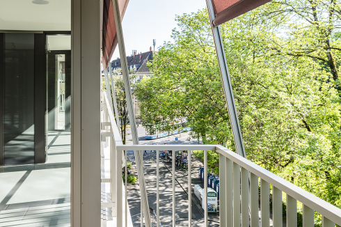 In den als Dreispänner organisierten Regelgeschos-sen faltet sich eine polygonale Loggia zu den Eschen entlang der Straße auf.<br />