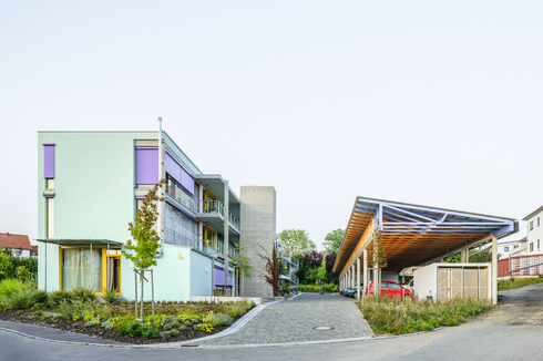 Einmal im Jahr findet auf dem Platz zwischen dem Wohngebäude und dem hölzernen Hallenbau ein Fest statt. Die Terrassen im Erdgeschoss sind Treffpunkt für den Plausch unter Nachbarn. 