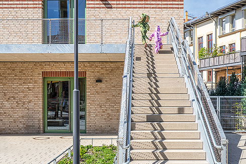 Über zwei einläufige Treppen gelangen die Kita-Kinder direkt aus den Gruppenräumen hinab in den Garten.