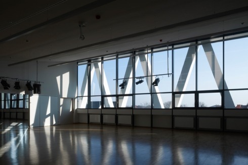 Die alten Fensteröffnungen blieben unverändert, sind in der neue Fassade lamellenartig perforiert abgebildet und sollen an Schallöffnungen eines Instruments erinnern.<br />