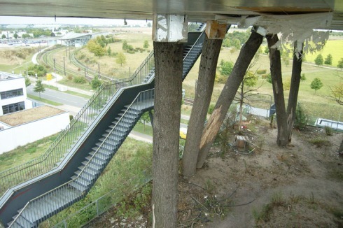 …steigt man hinab auf die Waldebene (im Hintergrund die U-Bahnstation Messe-Ost).<br />