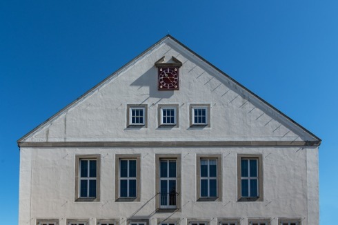 Der Ratssaal zeichnet sich zum Markt mit seinen großen Fenstern ab.<br />