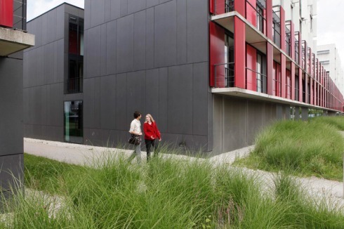 Ornament und Sonnenschutz: Die sieben verschiedenen Rottöne der pulverbeschichteten Aluminiumtafelfassade sind eine Referenz an den Namensgeber des Standortes, die Felsennelke.<br />