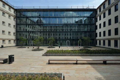 Spuren an der Fassade lassen Rückschlüsse auf die einstige Nutzung des Gebäudes zu: Gitterstäbe vor einigen Fenstern. <br />