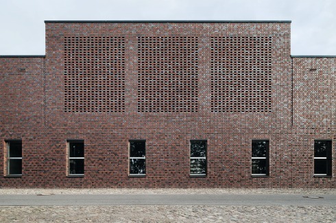 Neben der im Streiflicht changierenden Oberfläche des Materials wird die Fassade zusätzlich vom Schattenwurf dezenter Rücksprünge belebt <br />