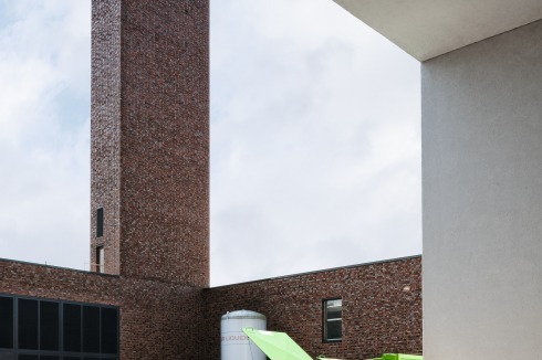 Der Entsorgungshof im Stalltrakt wird vom neuen Schornstein überragt, dessen Mauerwerk mit einzelnen hervorgezogenen Klinkerköpfen belebt ist<br /><span class="OffWhite"></span><br />