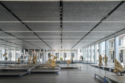 Im „Podium“, der Halle für temporäre Ausstellungen, hat Rem Koolhaas auch den Innenraum gestaltet. Die 60 altrömischen Kopien griechischer Bronzen stehen ohne Sockel auf Travertinplatten. Die Ausstellung „Serial Classic“ endet am 24. August.<br />