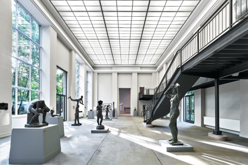 Das Mittelatelier. Im Boden sind die Gleise für den Steintransport nachgezeichnet. Das einstige Glasdach wurde nicht rekonstruiert, von der Decke scheint Kunstlicht. Die Fußpunkte der neu eingefügten Galerie erhielten passende Natursteinsockel.<br />