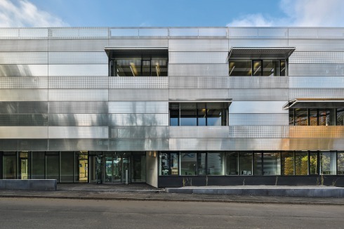 Die Fassade wirkt mit den unterschiedlichen Lochungen der Bleche sehr tech-noid. Die Kunst am Bau in den öffentlichen Bereichen gestaltete Gert Wiedmaier.<br />