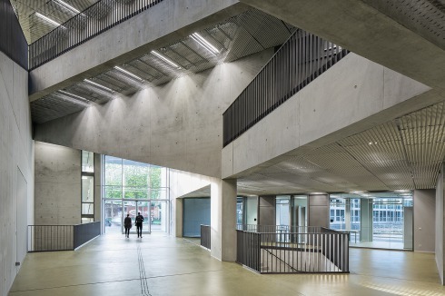 Sichtbeton und Streckmetallpaneele aus Aluminium prägen das Foyer (Blick zum Eingang Moritzstraße)<br />
