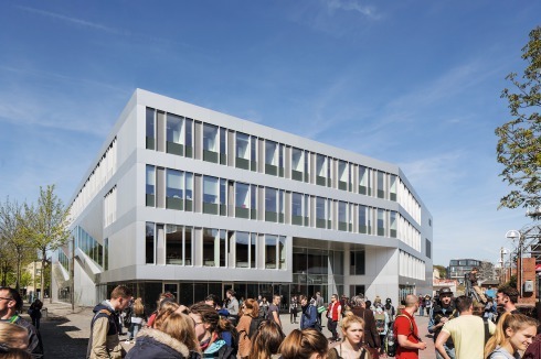 Eine große Auskragung signalisiert den Haupteingang zum Hörsaalzentrum. Der Knick in der Fassade lenkt den Blick auf die Norderweiterung des Campus.<br /><br />