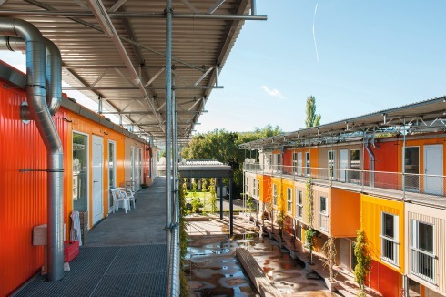 Die wechselseitig angeordneten Laubengänge entstehen durch Spiegelung und Versatz der mittleren Ebene und werden beidseitig über Stahltreppen erreicht. Ihre Dächer wurden mit Resten der Lagerhalle bedeckt. Die Laubengangstützen sind Regenfallrohr und Kletterpflanzenhalter zugleich. Auf dem Dach befindet sich eine Solaranlage.<br />