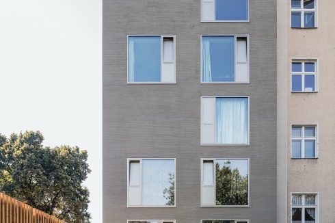 Ansicht von Norden mit dem privaten Garten. Die flächenbündigen Fenster sind festverglast und haben nur schmale Öffnungsflügel aus eloxierten Aluminiumpaneelen.<br />