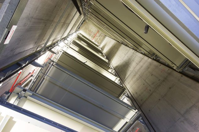 Das Parksystem kann 26 Fahrzeuge über ein vertikales Transportsystem auf beidseitig angeordnete Parkfächer befördern.